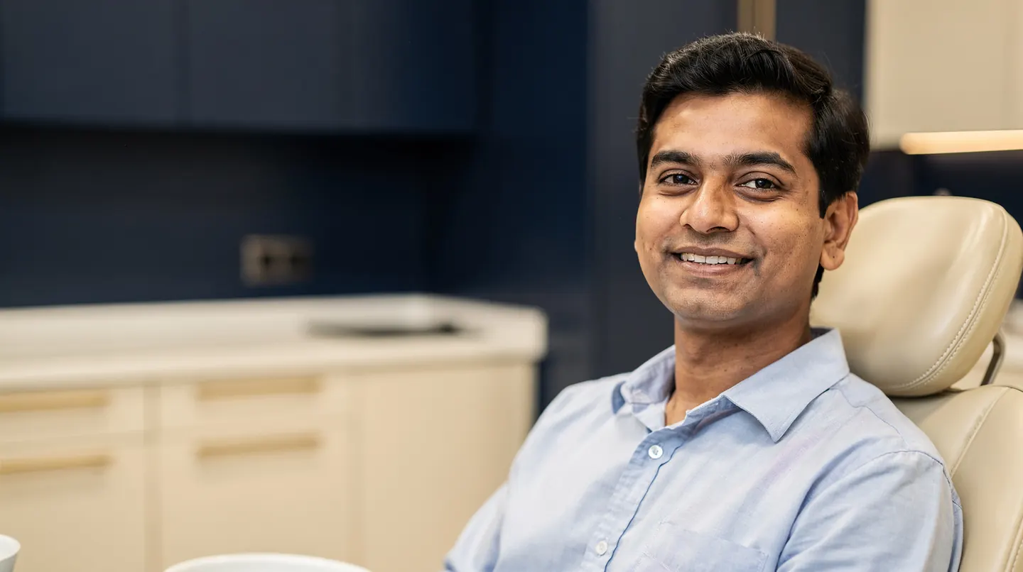 Illustrative picture: a man sitting relaxed in a dental chair with a relieved smile