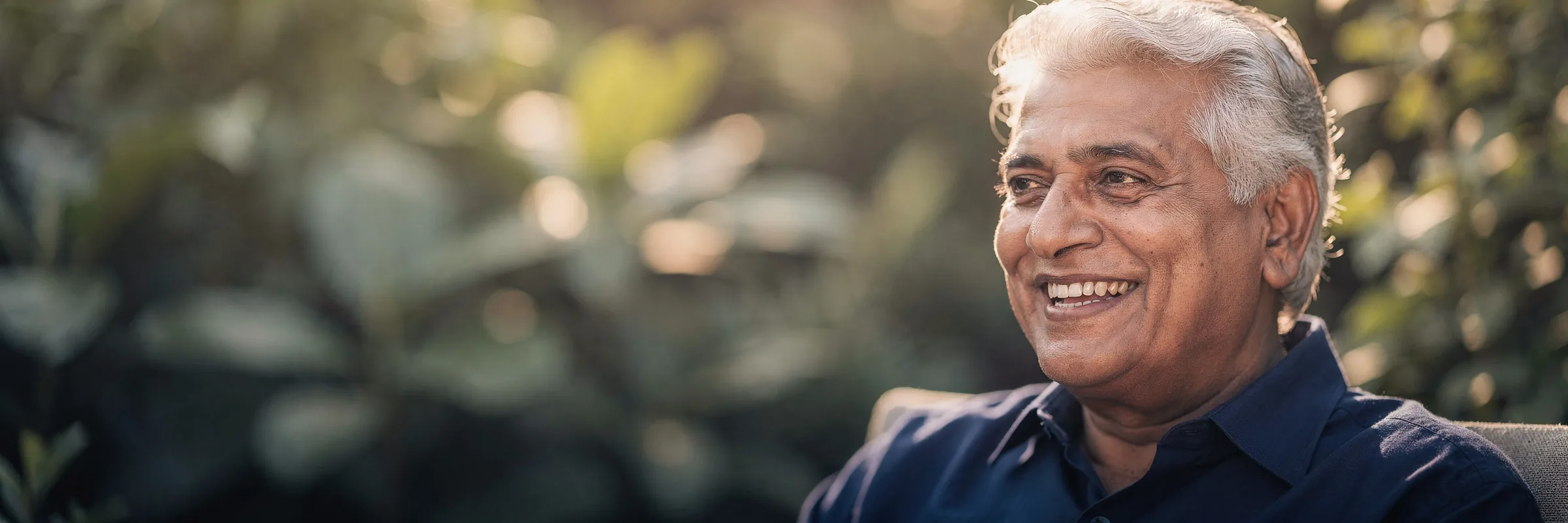 Illustrative picture: a man with silver hair smiling confidently in a garden