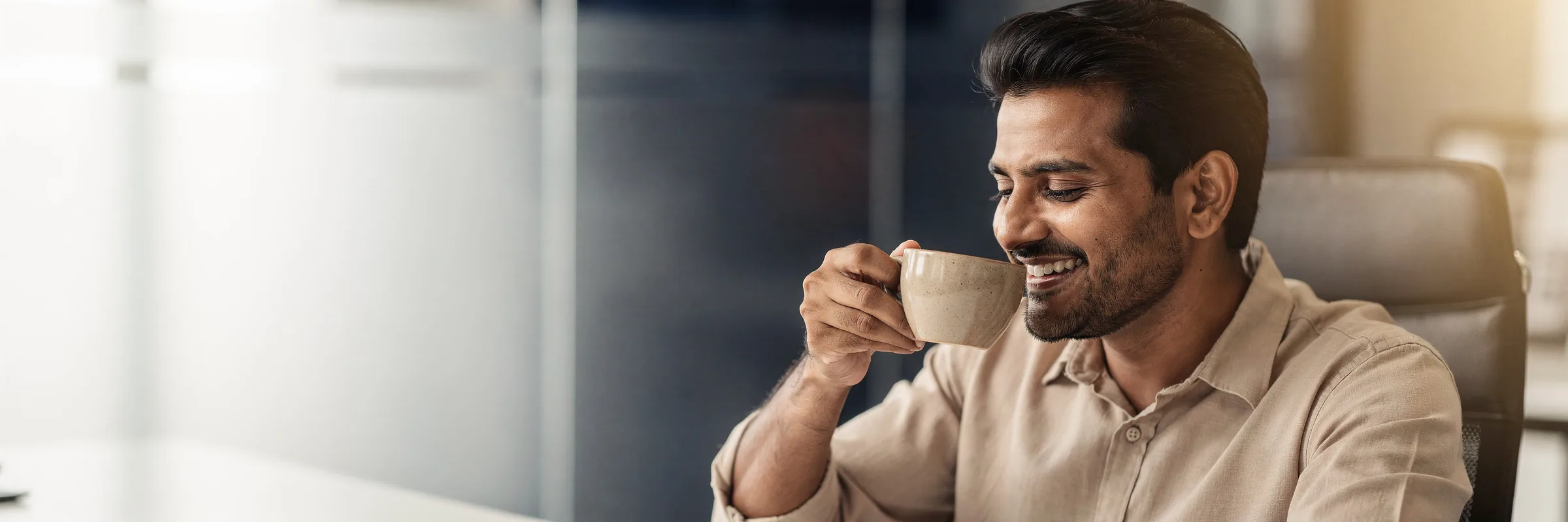 Illustrative picture: a man smiling with relief over a cup of tea