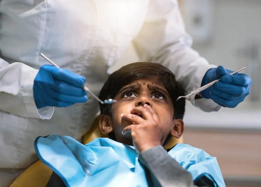 Child in dental chair looking up with anxiety